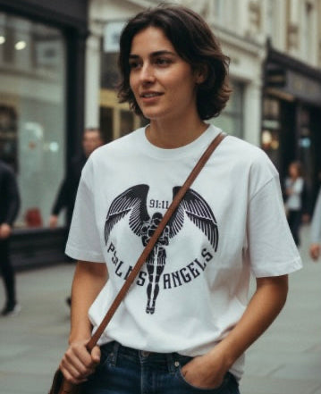 Woman wearing a white t-shirt with a Psalms Angels logo, standing on a street.