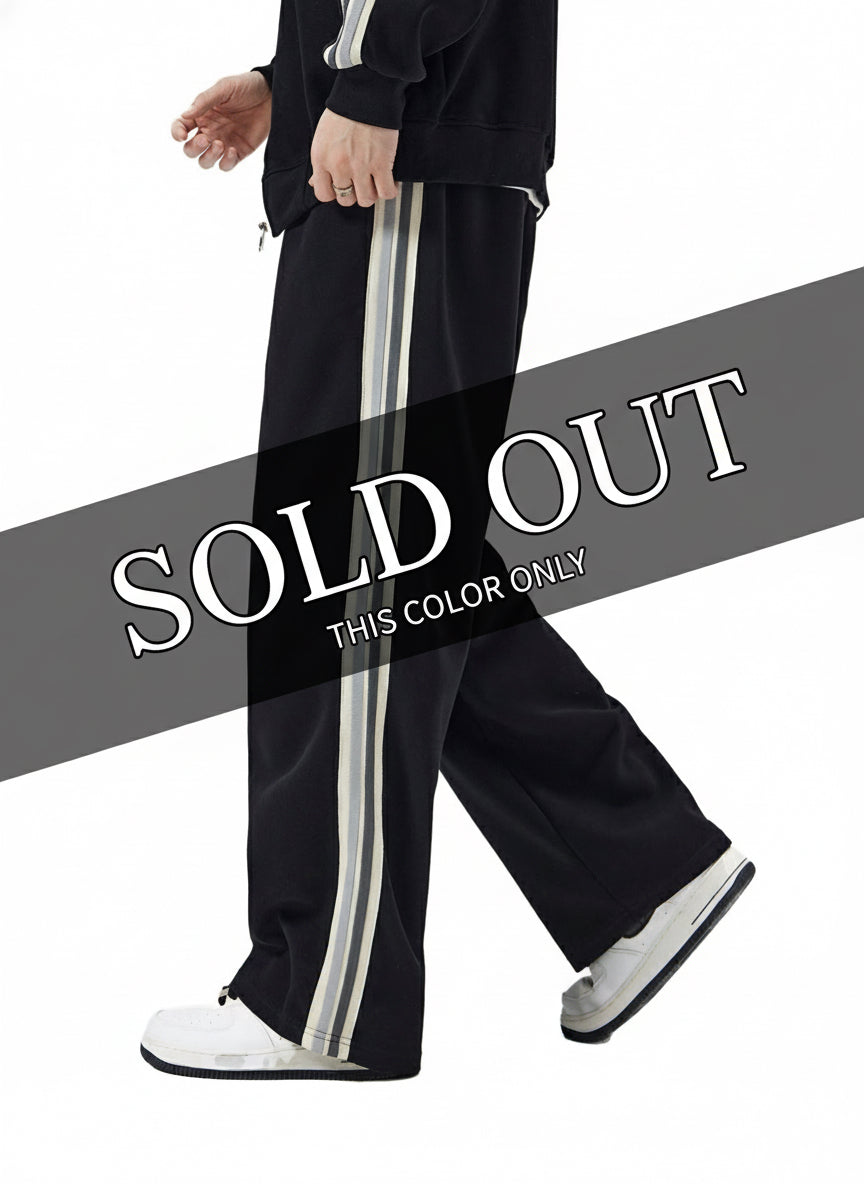 Black side stripe sweatpants with a Psalms Angels logo on a white background side view